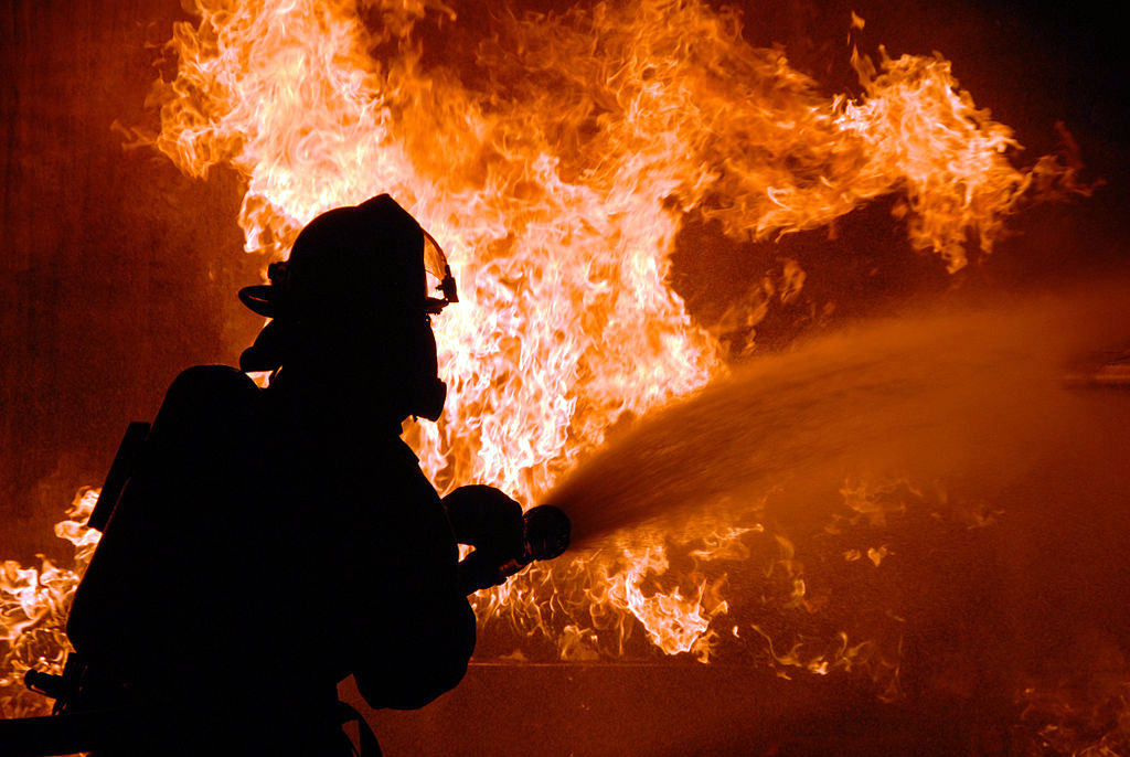 Firefighter using a hose on a fire