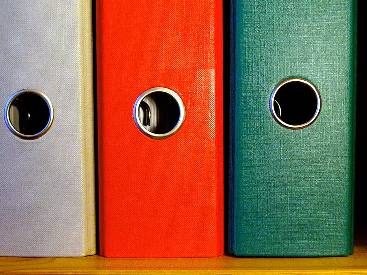 photo closeup of three binders on a shelf